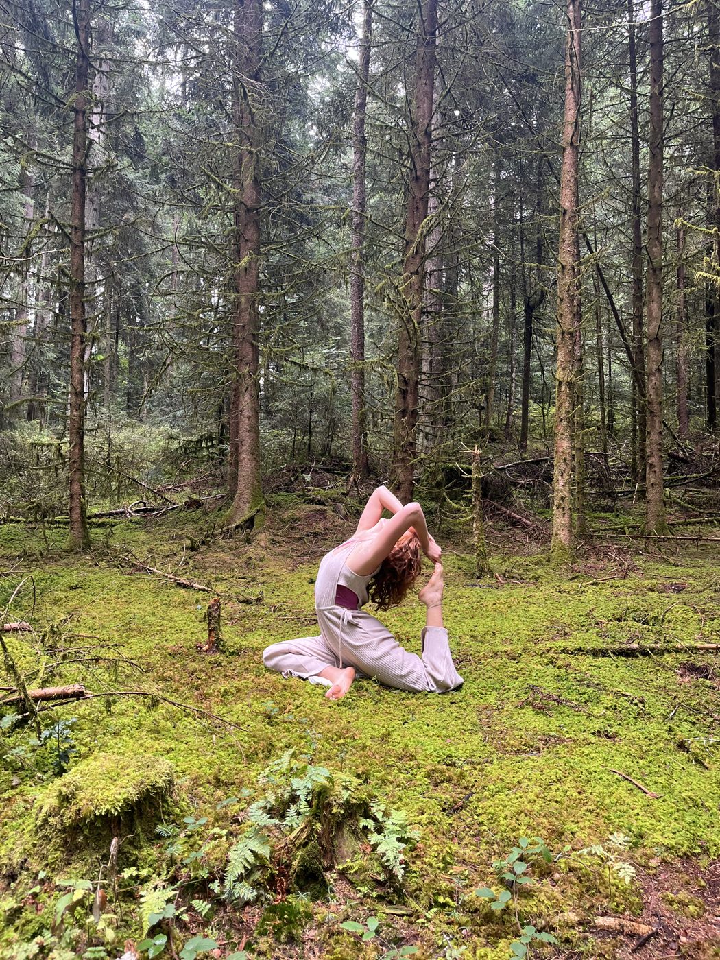 Jazmin practicando yoga sobre el musgo