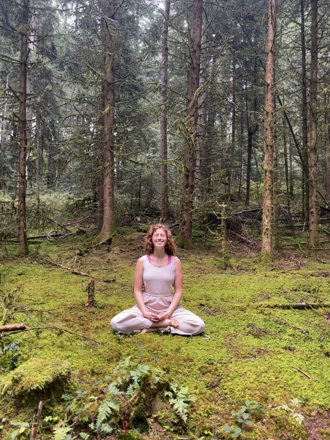 Jazmin sentada en meditación sobre el musgo